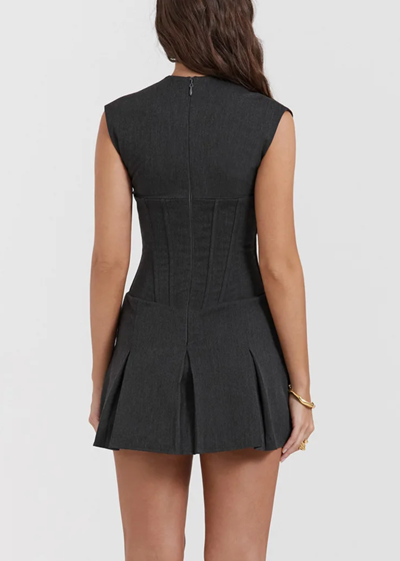 Black sleeveless dress worn by a person on a white background