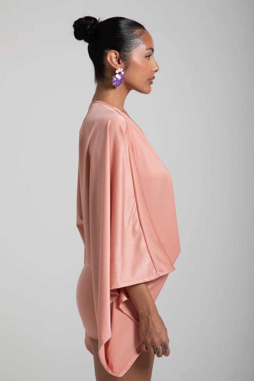Woman wearing a pink outfit against a gray background