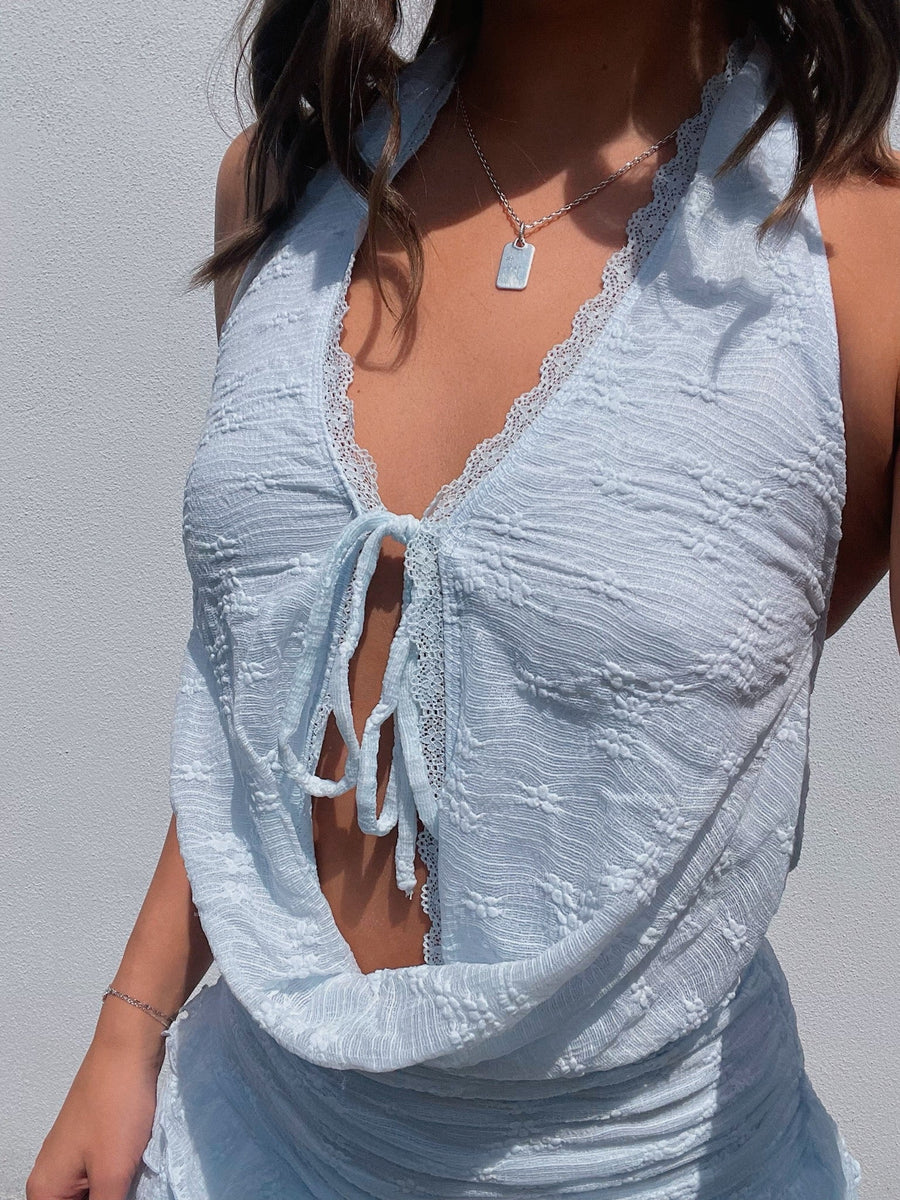Light blue textured top worn by a person against a neutral background