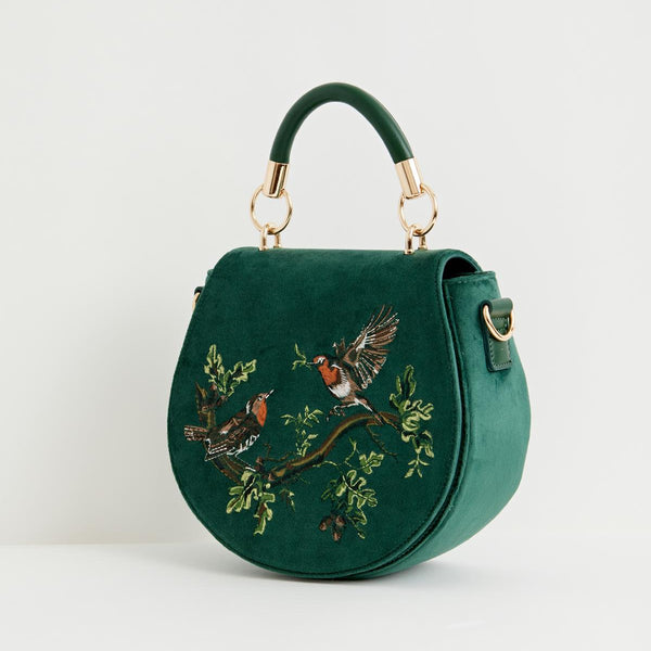 Green handbag with bird embroidery on a white background