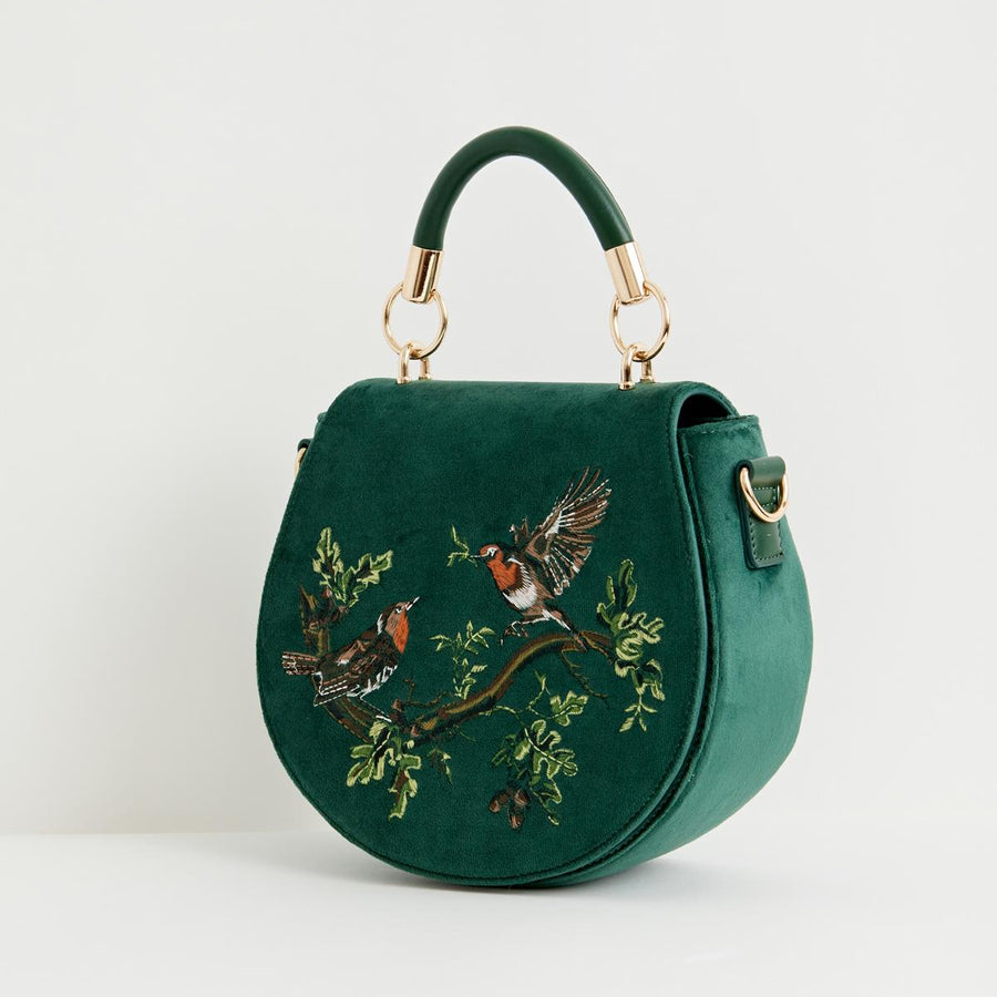 Green handbag with bird embroidery on a white background