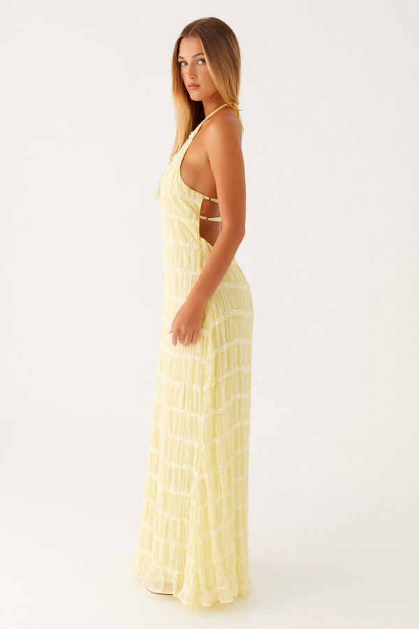 Woman wearing a yellow dress with cut-out design on a white background