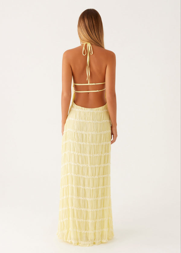 Woman wearing a yellow halter top and skirt set on a white background