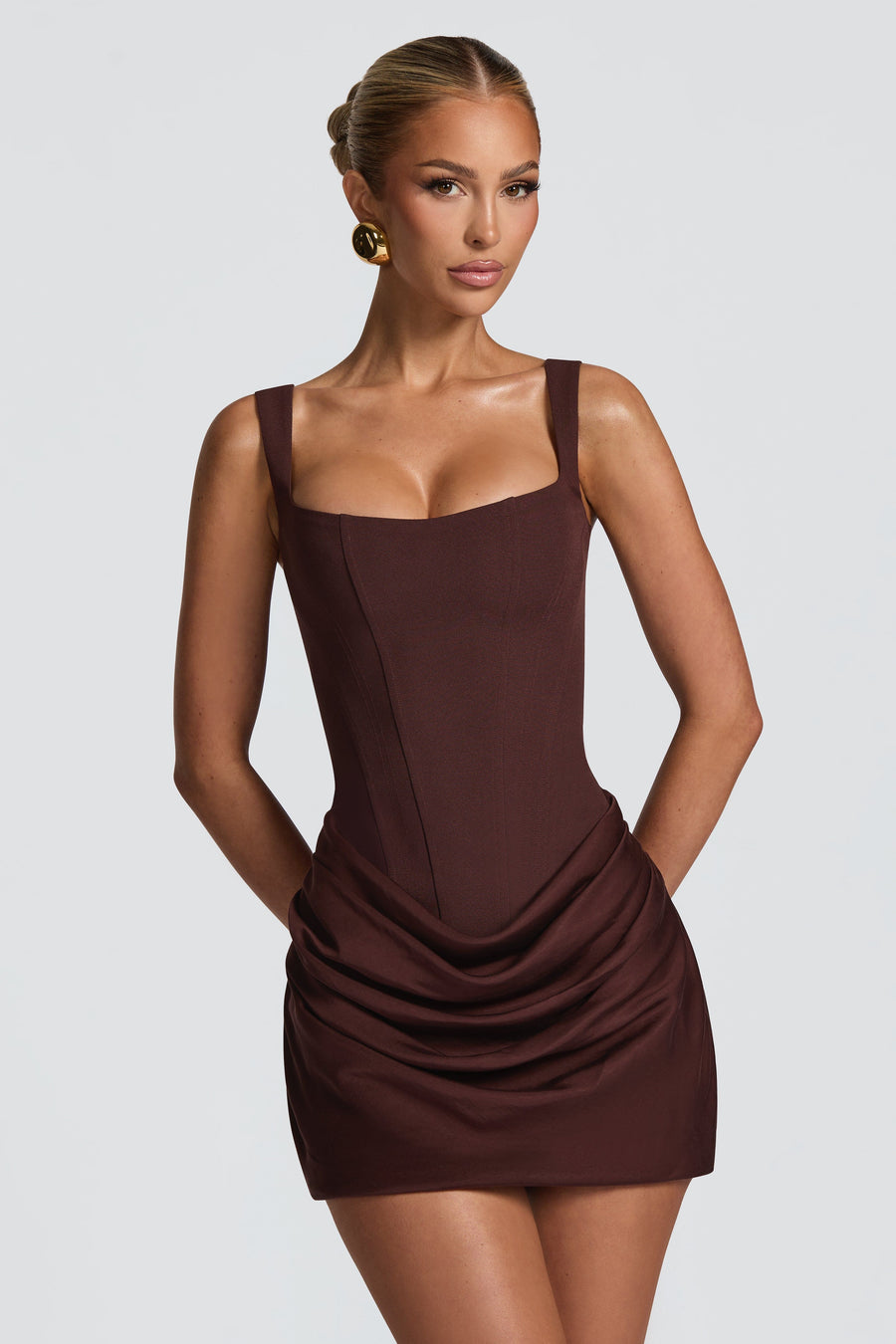 Woman wearing a brown dress against a plain background